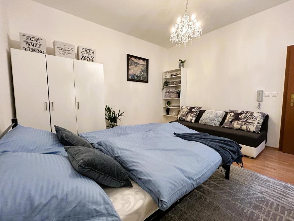 a bedroom with two beds and a chandelier at Luxusný apartmán v centre mesta in Piešťany