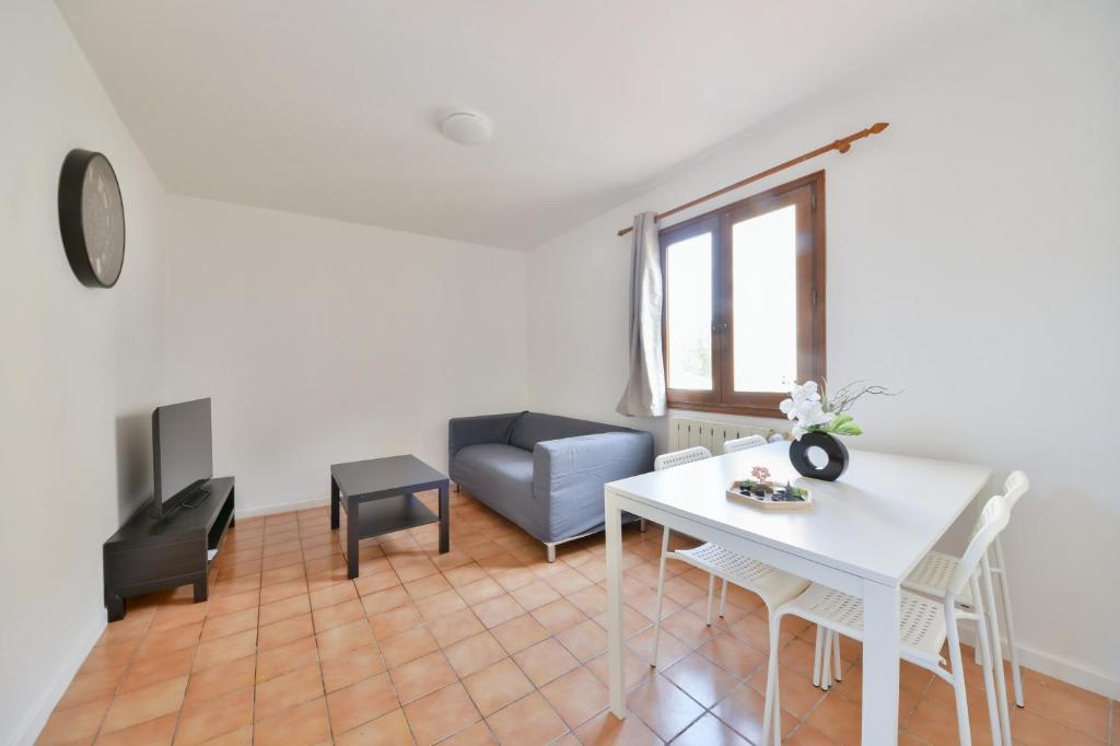 un salon avec une table blanche et un canapé dans l'établissement Pleasant Appartment near Stade de France, à Saint-Denis