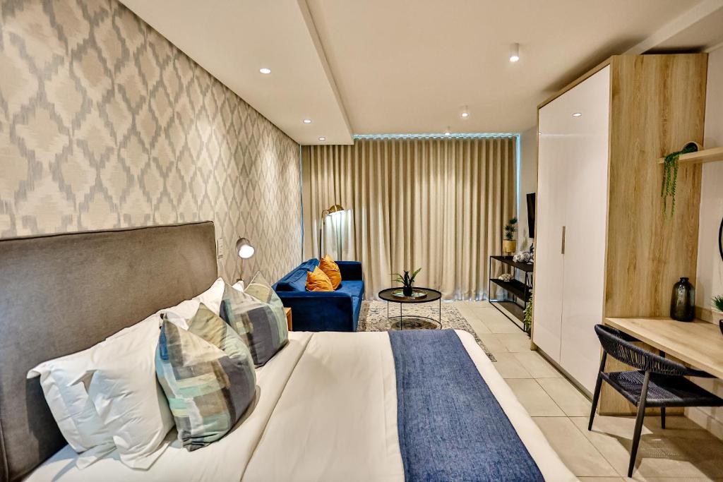 Habitación de hotel con cama y sofá en Zimbali Lakes Resort, Boulevard Suite, Ballito en Ballito