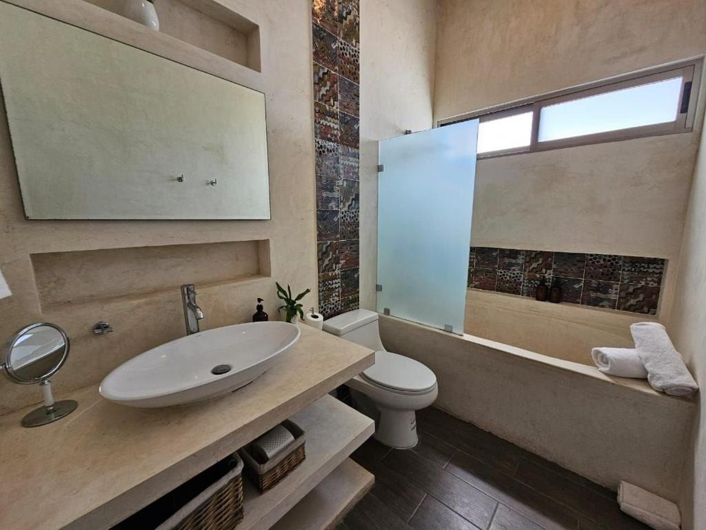 a bathroom with a sink and a toilet and a tub at Casa Américas in Mérida