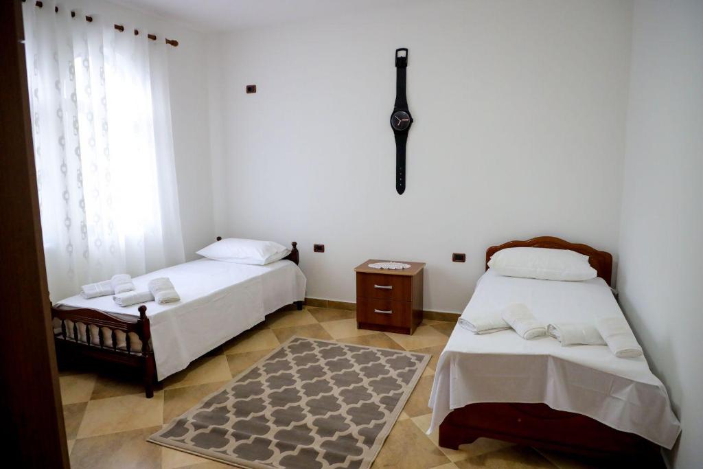um quarto com 2 camas, uma janela e um tapete em Vila Taga Guesthouse em Krujë