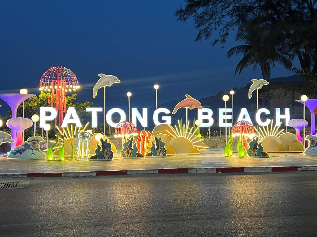 a large sign that says dancing beach at night at Patong Vacation Rentals - Located in the Heart of Patong, Studio Apartments walking distance to the beach, King Bed, Kitchen, Private Bathroom, Seating Area, 65" Smart TV with Free WIFI in Patong Beach