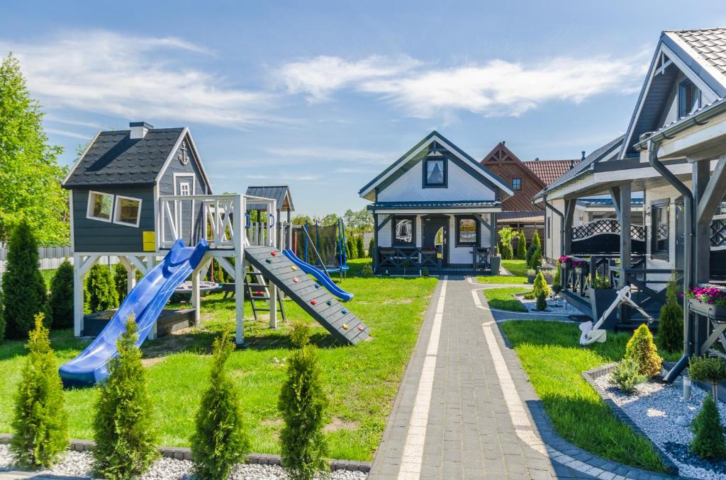 einen Spielplatz in einem Wohnviertel mit Häusern in der Unterkunft Domki letniskowe Agata in Jantar