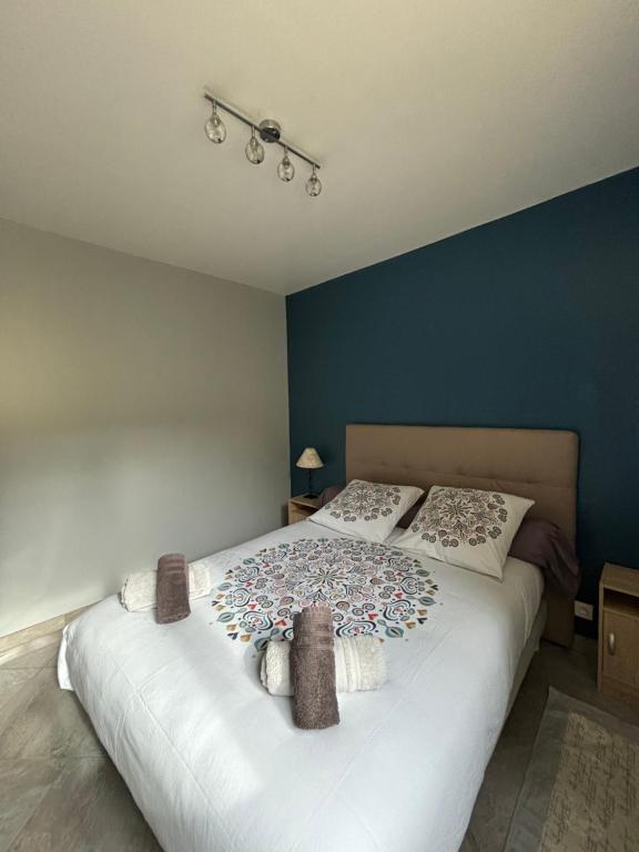 une chambre avec un grand lit blanc avec deux oreillers dans l'établissement Rez-de-chaussée de plain-pied avec parking privé au centre ville, à Dieppe