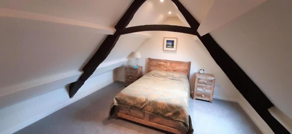 a bedroom with a bed in a attic at LetAway - The Curtain (13th Century Cottage) in Richmond