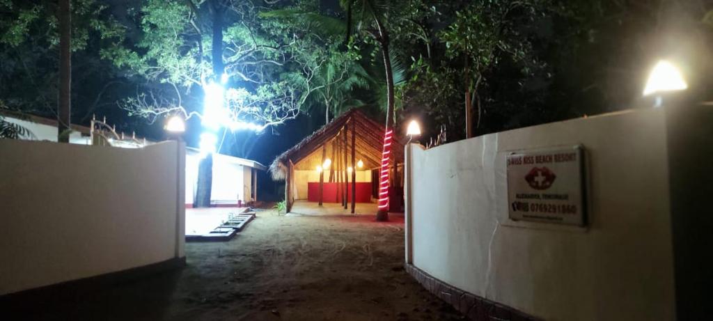 eine Scheune in der Nacht mit Lichtern hinter einem Zaun in der Unterkunft Swiss kiss beach resort in Uppuveli