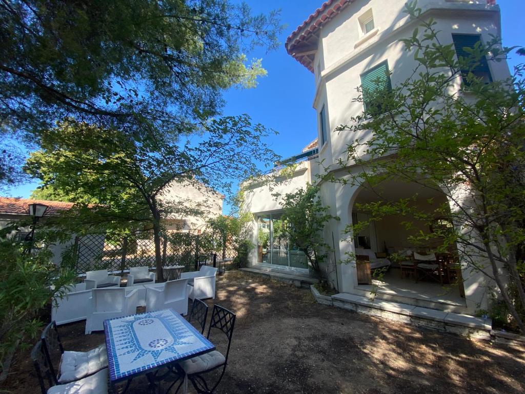une maison avec une table et des chaises dans la cour dans l'établissement LA CIOTAT 3 chambres plage et jardin, à La Ciotat