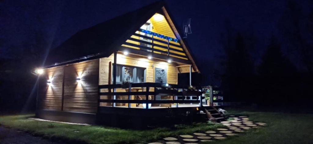 a small wooden house with lights on it at night at Domek Skitnica in Mirsk