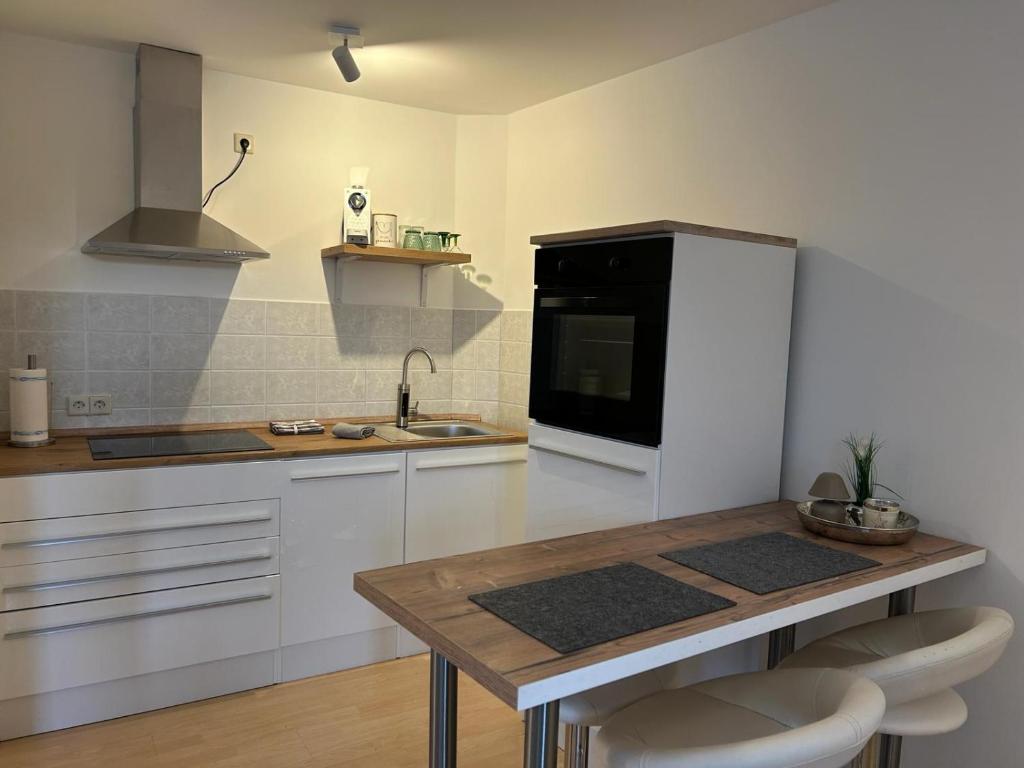 a kitchen with white cabinets and a black microwave at Ferienwohnung Forchtenberg in Forchtenberg