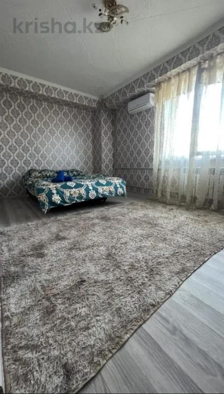 Llit o llits en una habitació de Квартира 55 в самом центре Шымкента