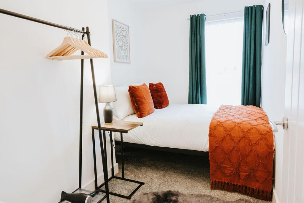 1 dormitorio con cama, lámpara y ventana en Town Center Retreat Stylish 3 Bed Accommodation, en Saint Helens