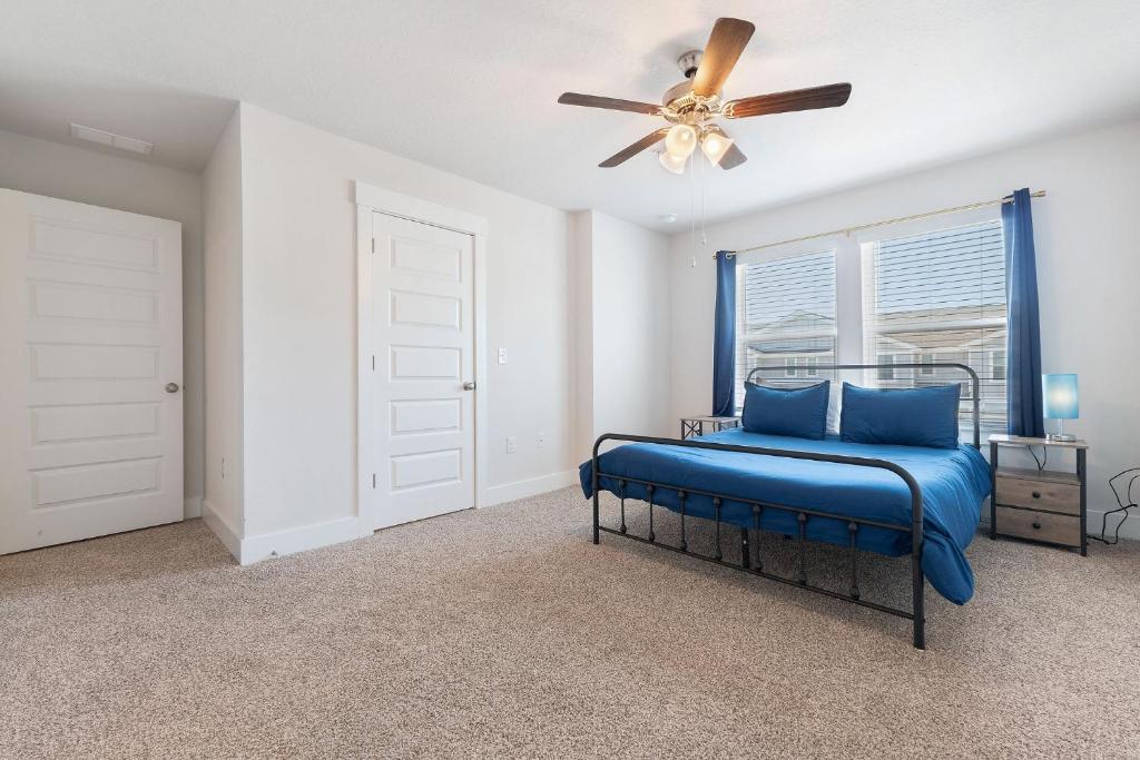 um quarto com uma cama azul e uma ventoinha de tecto em Admiral's Quarters Suite em Pensacola