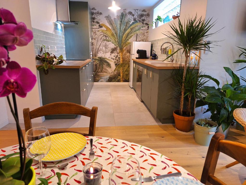 cocina y comedor con mesa y plantas en Loft CAPUCINE au calme avec jardins 70m2 en Montreuil