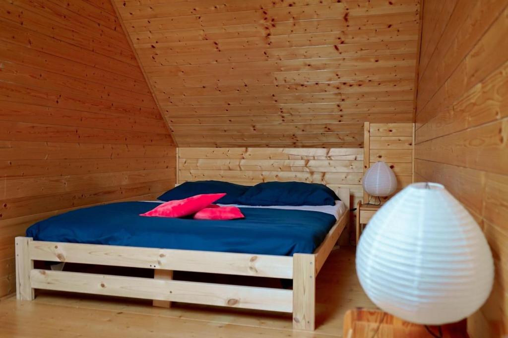 1 dormitorio con 1 cama en una habitación de madera en Domki Krasne Morze en Mielenko