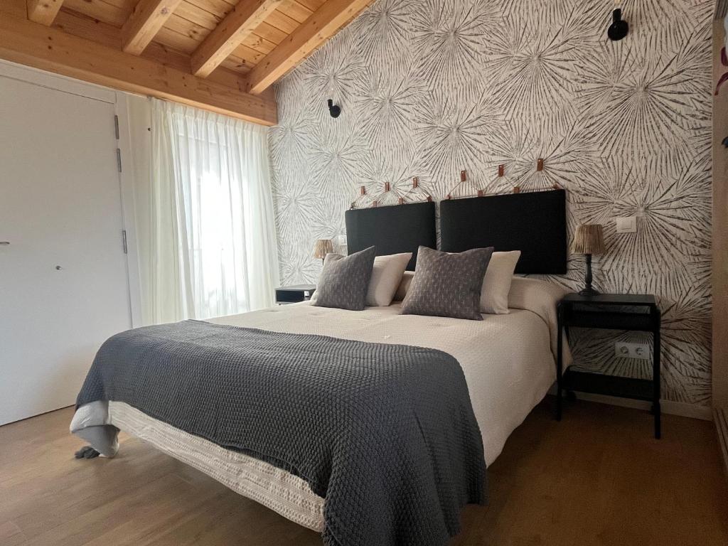 sypialnia z dużym łóżkiem i ścianą w obiekcie Apartamentos Sierra w mieście Ezcaray