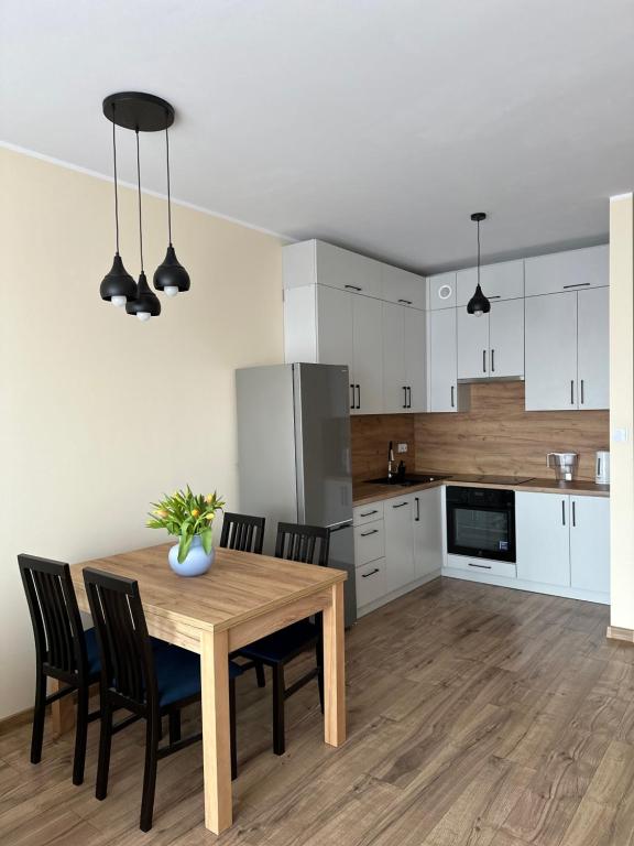 a kitchen and dining room with a wooden table and chairs at Apartament Jasna Góra in Częstochowa