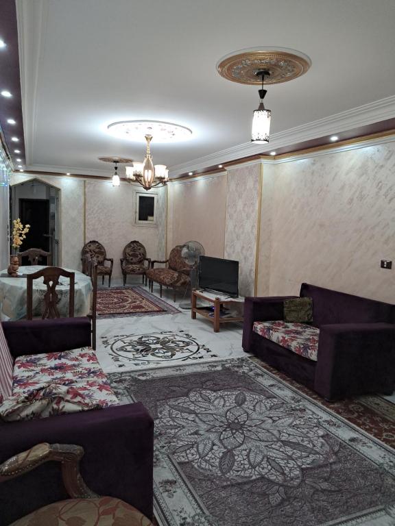 - un salon avec des canapés violets et un tapis dans l'établissement شقة مميزة جدا في قلب العاصمة قريبة من جميع الأماكن والخدمات, au Caire