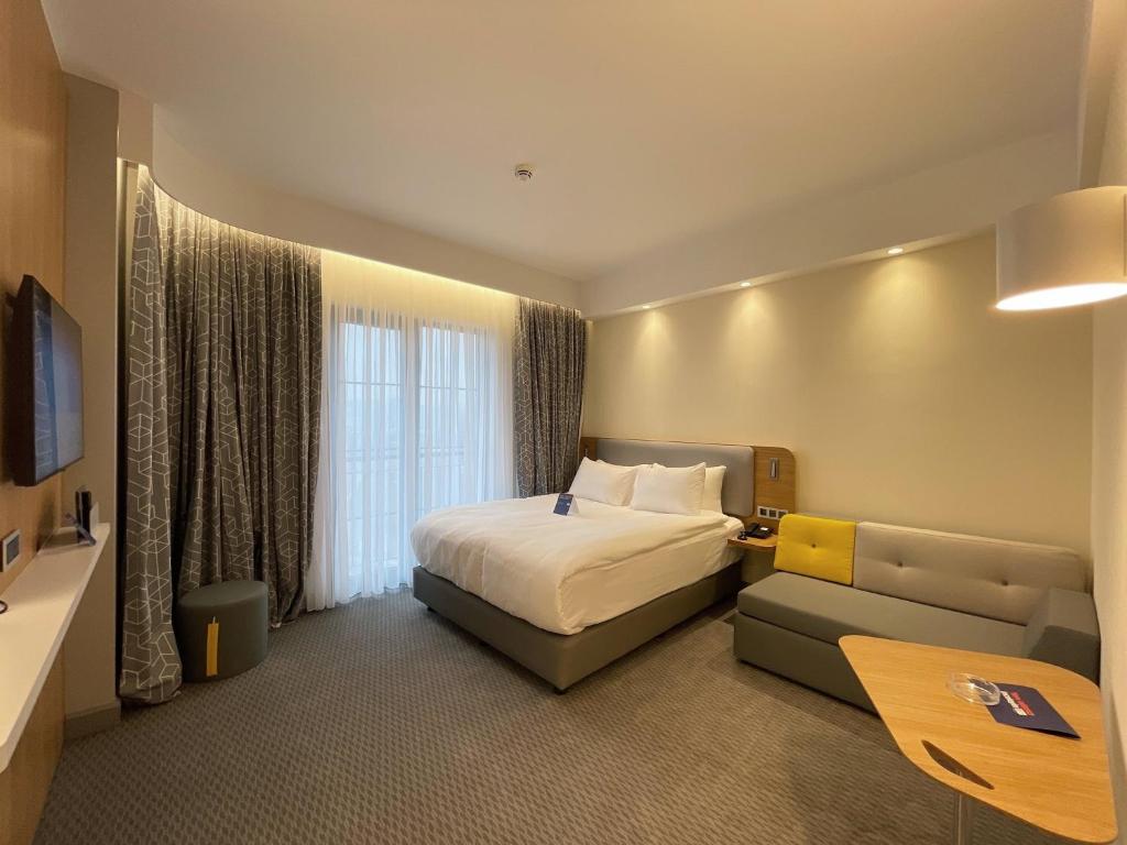 a hotel room with a bed and a couch at Holiday Inn Express - Ankara - Airport by IHG in Ankara