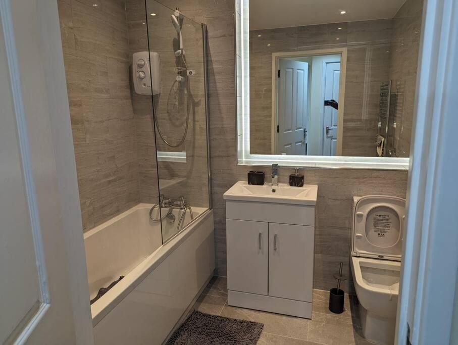 a bathroom with a sink and a shower and a toilet at Newly Launched Two Bedroom House By Den Accommodation Short Lets & Serviced Accommodation With Garden in London
