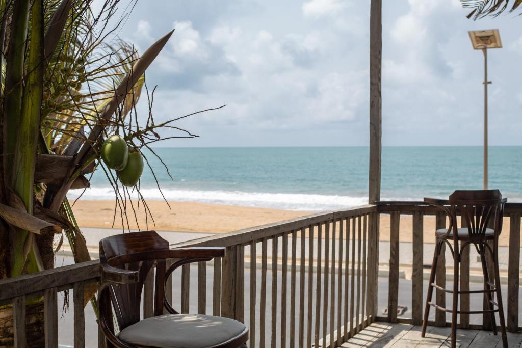 a balcony with chairs and a view of the beach at Tahiti Hotel in Cotonou