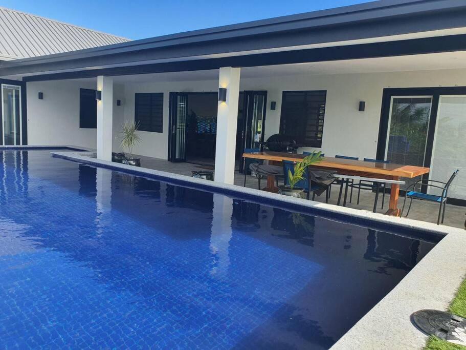 a swimming pool in front of a house at Harmonious Bella Villa in Pacific Harbour