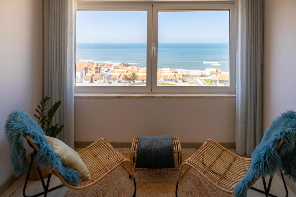 um quarto com duas cadeiras e uma grande janela em Blue House in Santa Cruz with Sea View em Santa Cruz