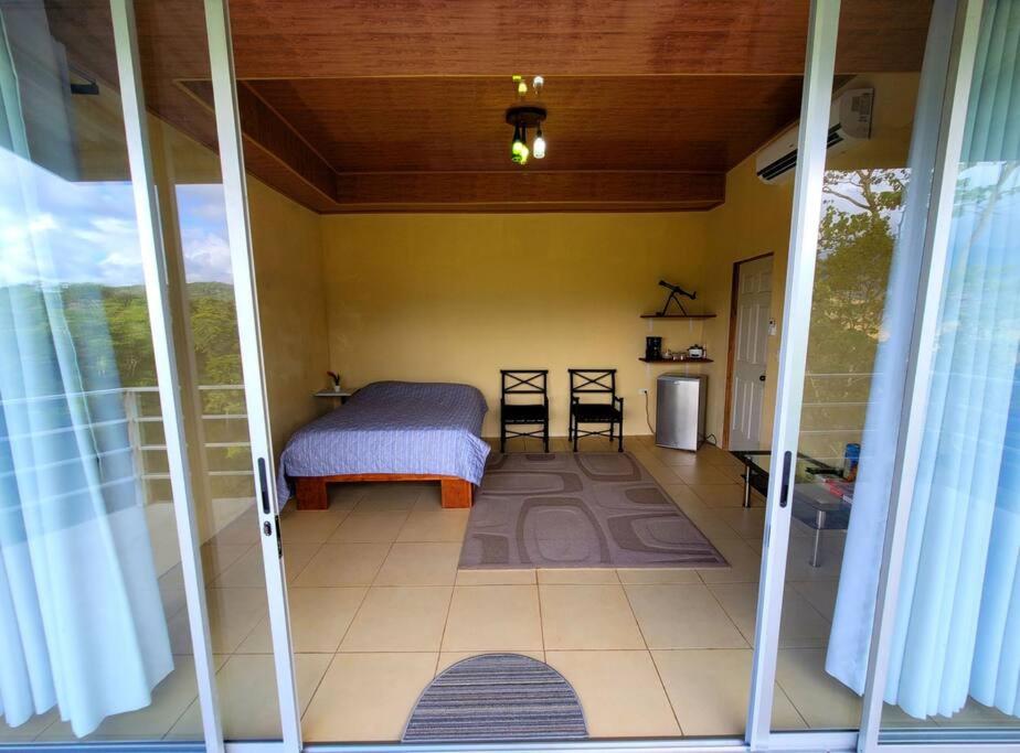 een slaapkamer met een bed in een kamer met een raam bij Suite Frente a la Cascada in Tierras Morenas