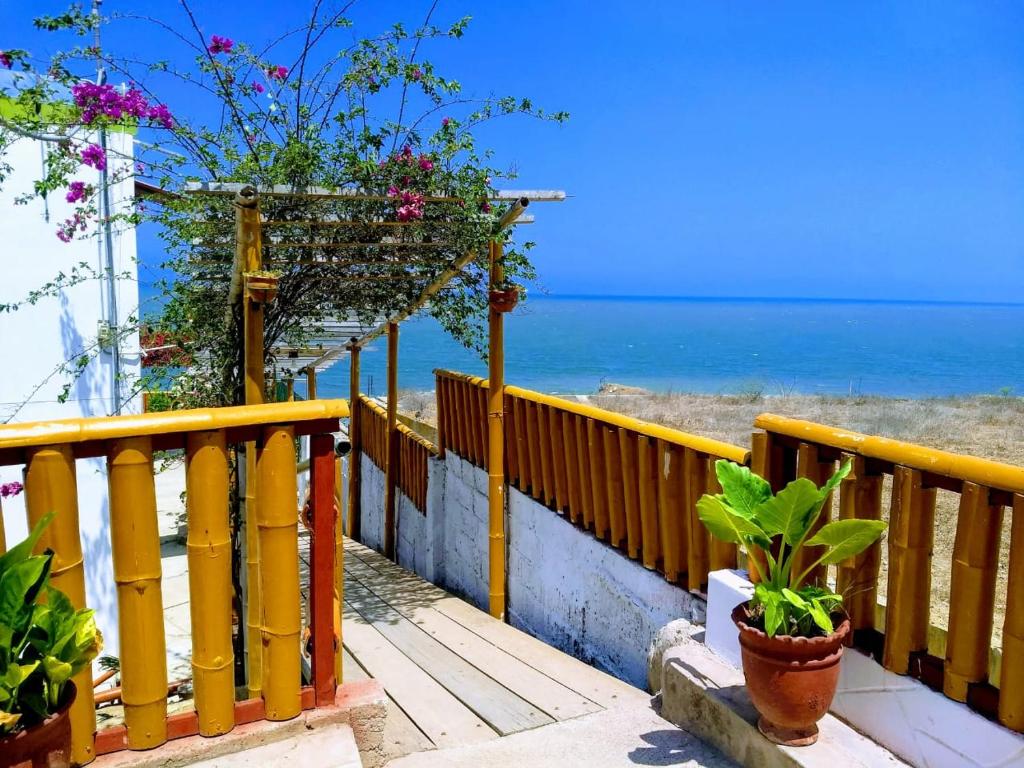 a yellow fence next to the beach with flowers at Punta Cocos Beach Casitas in Zorritos