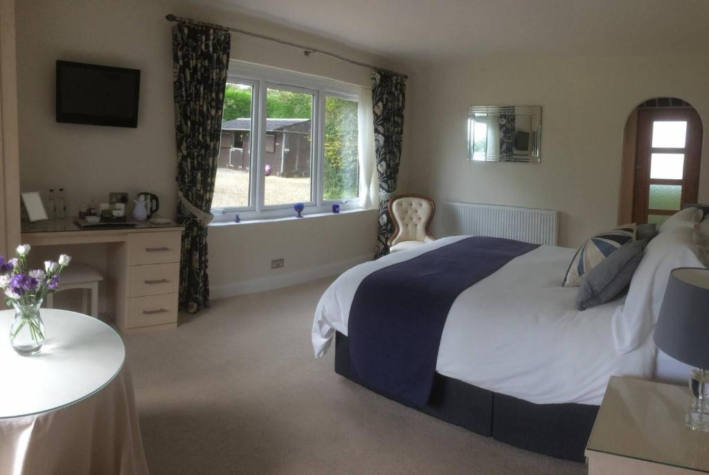sypialnia z dużym łóżkiem i oknem w obiekcie Brooklands w mieście Tavistock