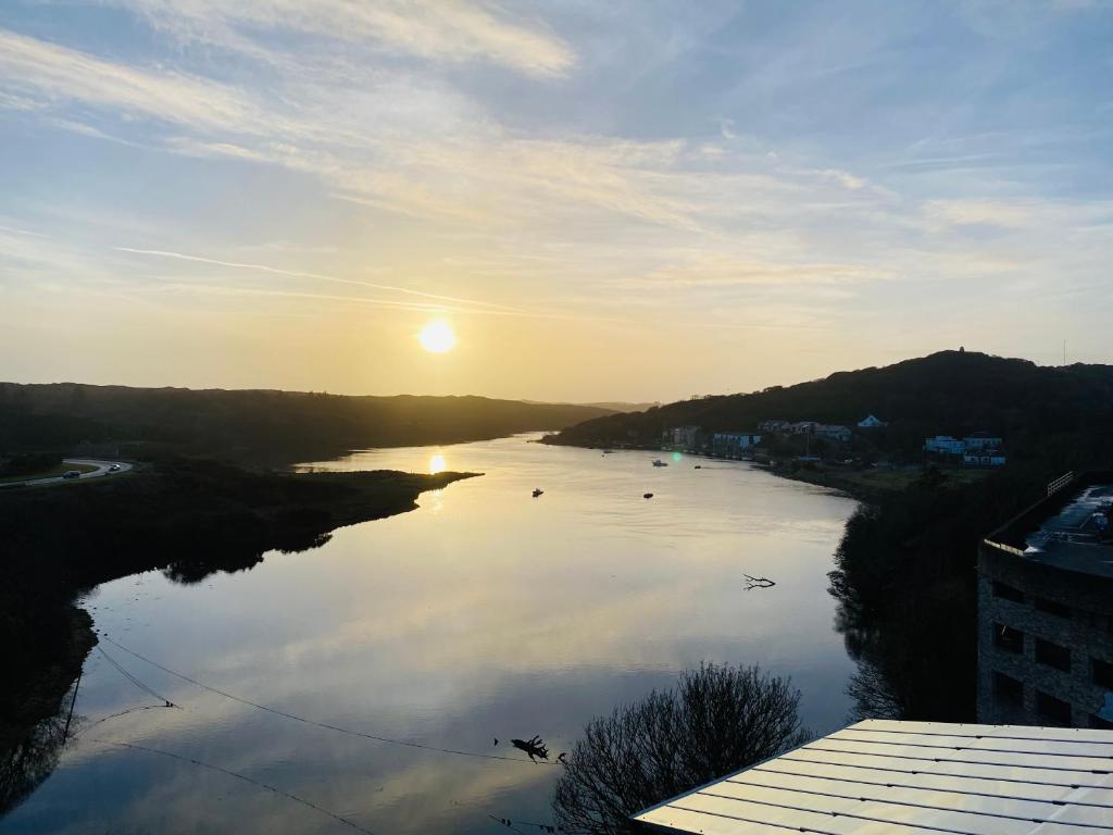 a view of a river with the sun setting at Apartment 6 @ Clifden Bay Apartments in Clifden