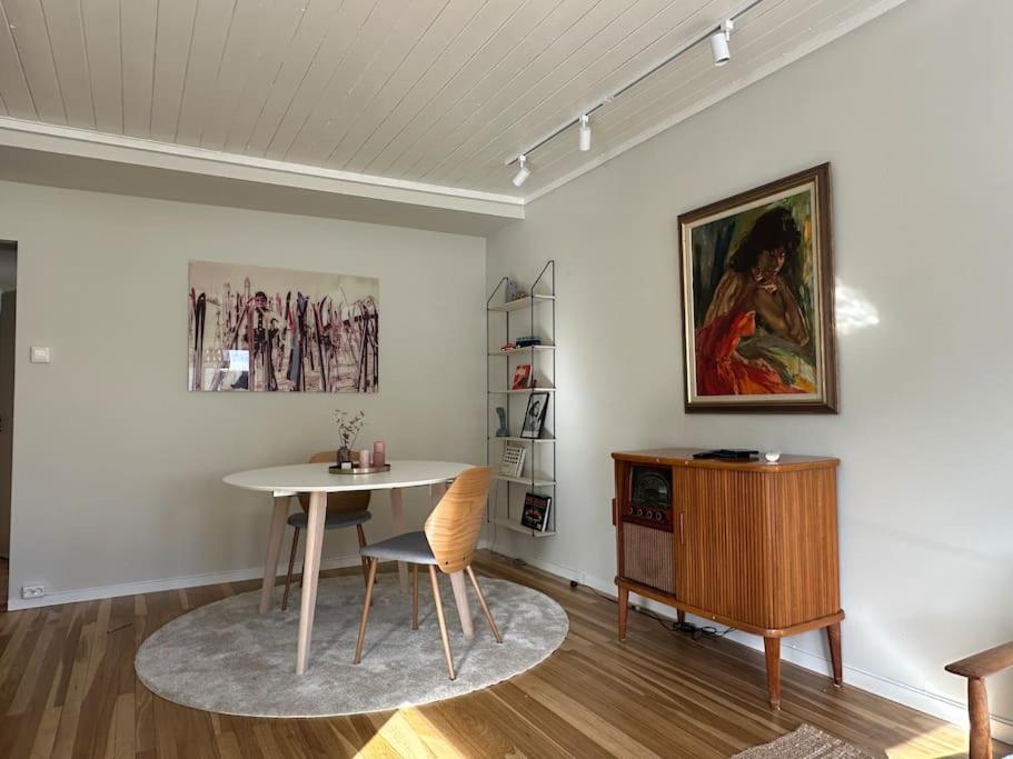 un comedor con una mesa y una pintura en la pared en Sentralt og nyoppusset, en Stavanger