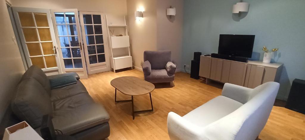 un salon avec un canapé, des chaises et une télévision dans l'établissement Le paradis face au marché, à La Rochelle