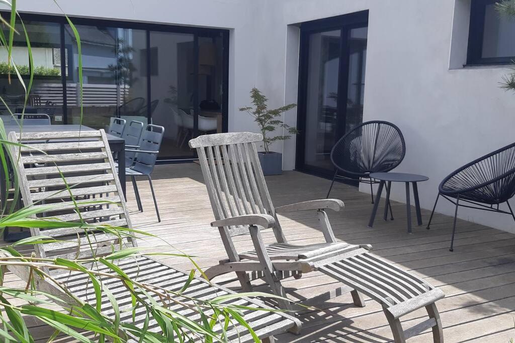 un grupo de sillas y mesas en un patio en Une maison en ville - Jardin - Au calme en Lorient