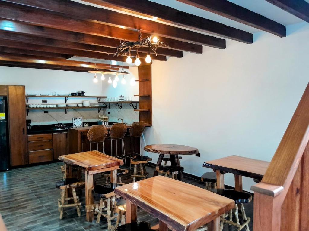 a room with wooden tables and chairs and a kitchen at Casa Iris Hotel Boutique in Barichara