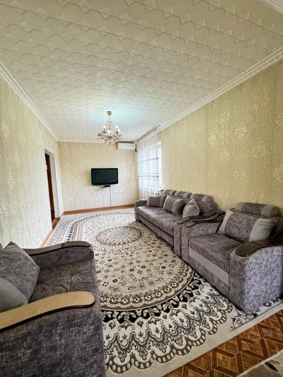 a living room with a couch and a television at 46 Самый центр Идеально для командированных и туристов Чисто оснащенно исправно уютно вместительно in Shymkent