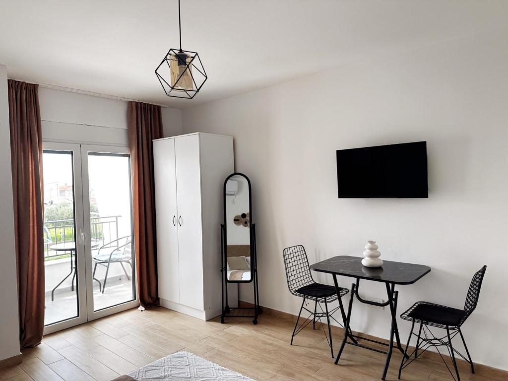 uma sala de estar com uma mesa e uma televisão em Danin apartmani em Bar