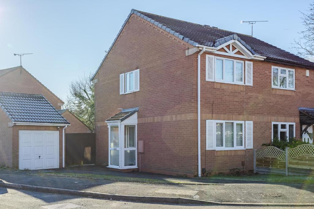 a red brick house with a white garage at UHCW House Coventry in Coventry