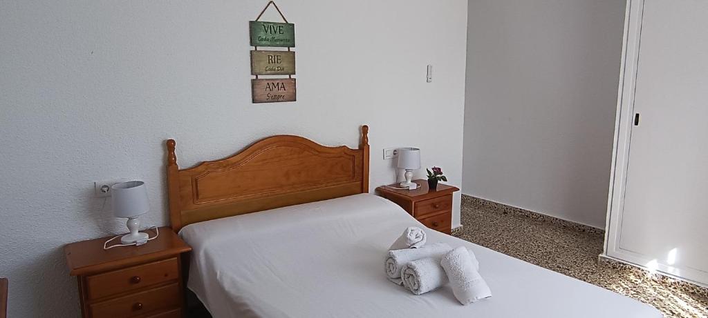una camera da letto con un letto e due asciugamani di El Dorado apartamento a Santa Pola