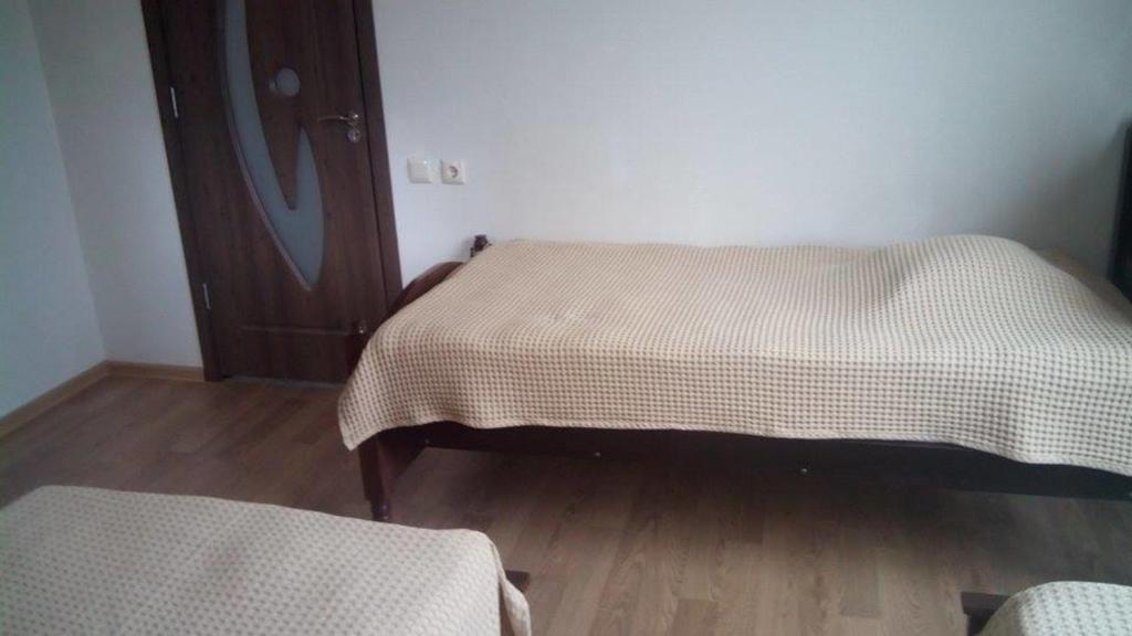 a bedroom with two beds and a wooden floor at Guest House Batumi in Batumi