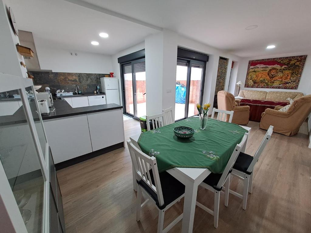 una cucina e una sala da pranzo con tavolo e sedie verdi di CASA CATALINA a Priego de Córdoba