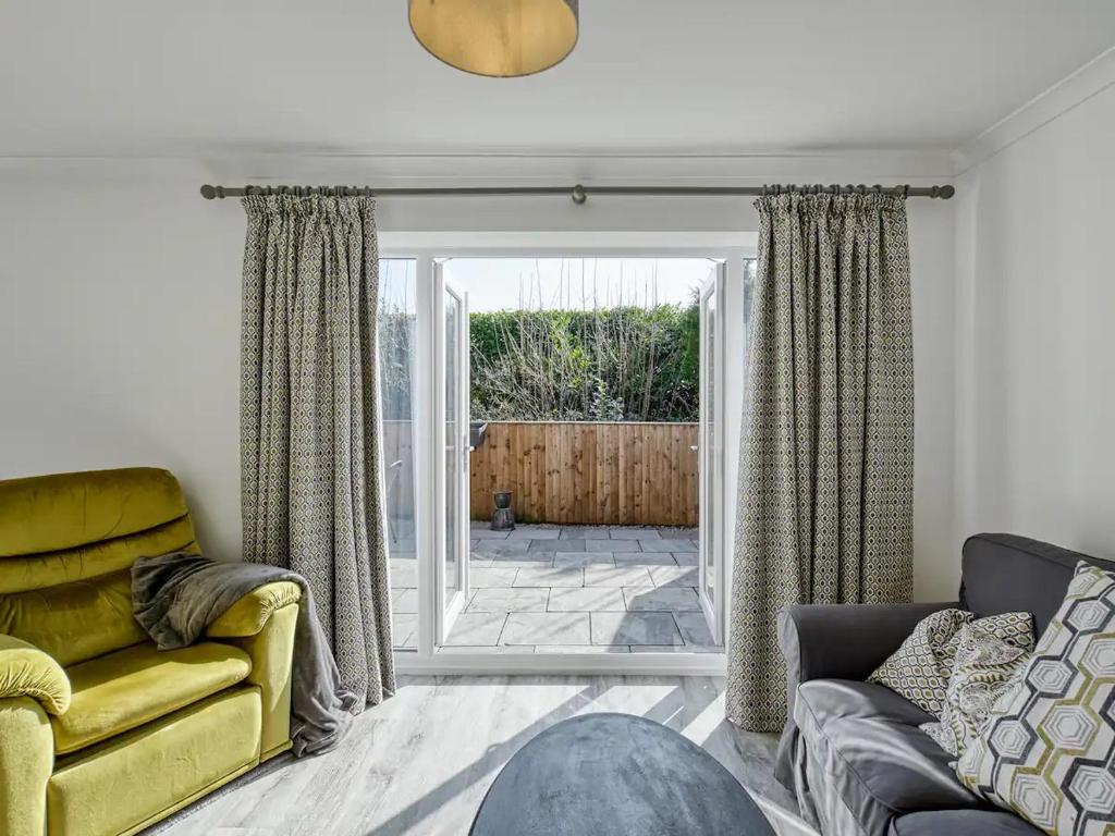 een woonkamer met een gele bank en een glazen schuifdeur bij Pass the Keys Modern Quiet House Airport Links Pass the Keys in Cheadle