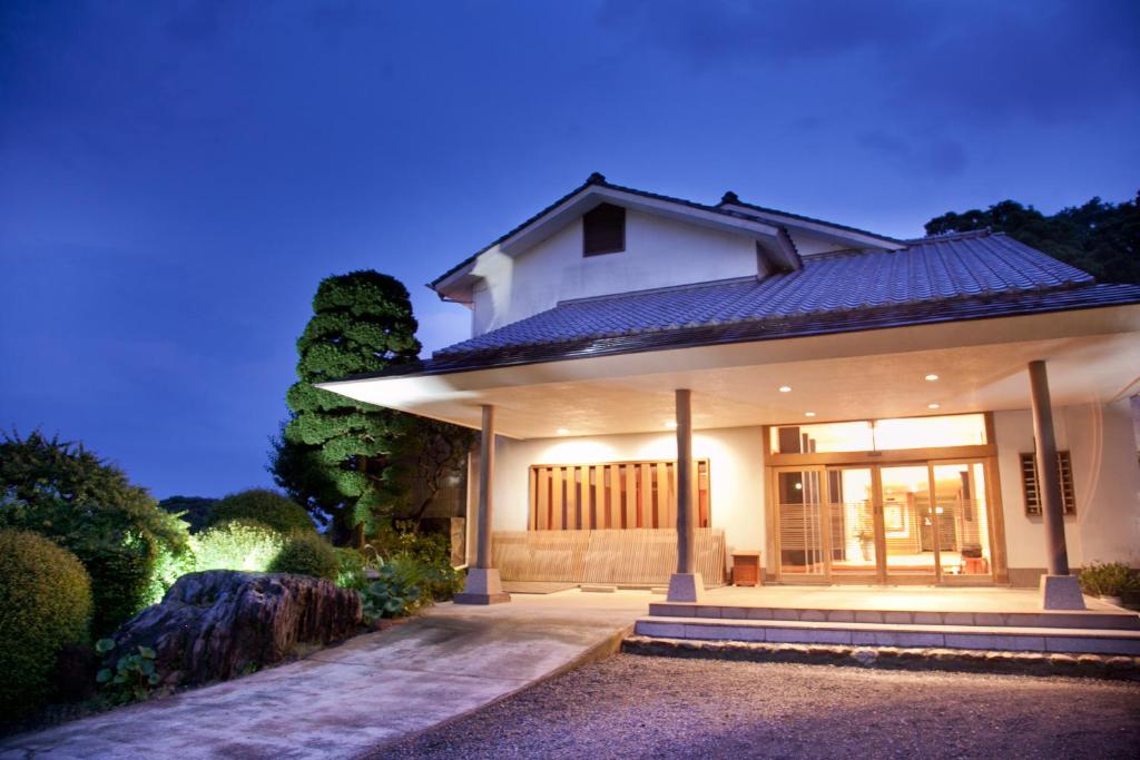 a small white house with a porch at night at Isaribi (No Children) in Higashiizu