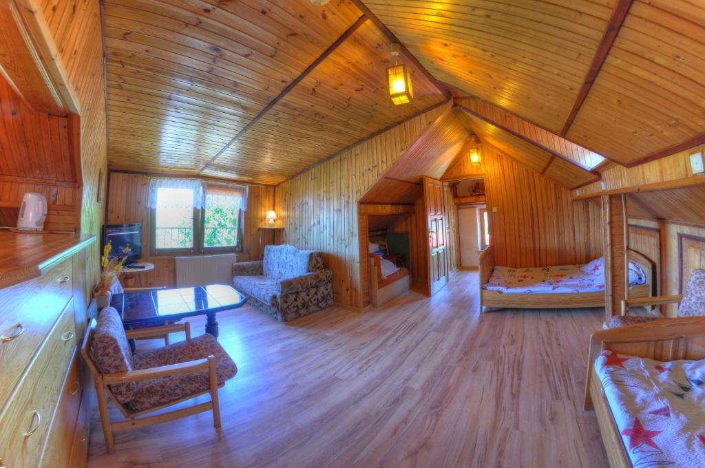 ヤロスワビエツにあるSłoneczna Przystańの木製の天井が特徴の広い客室で、リビングルームが備わります。