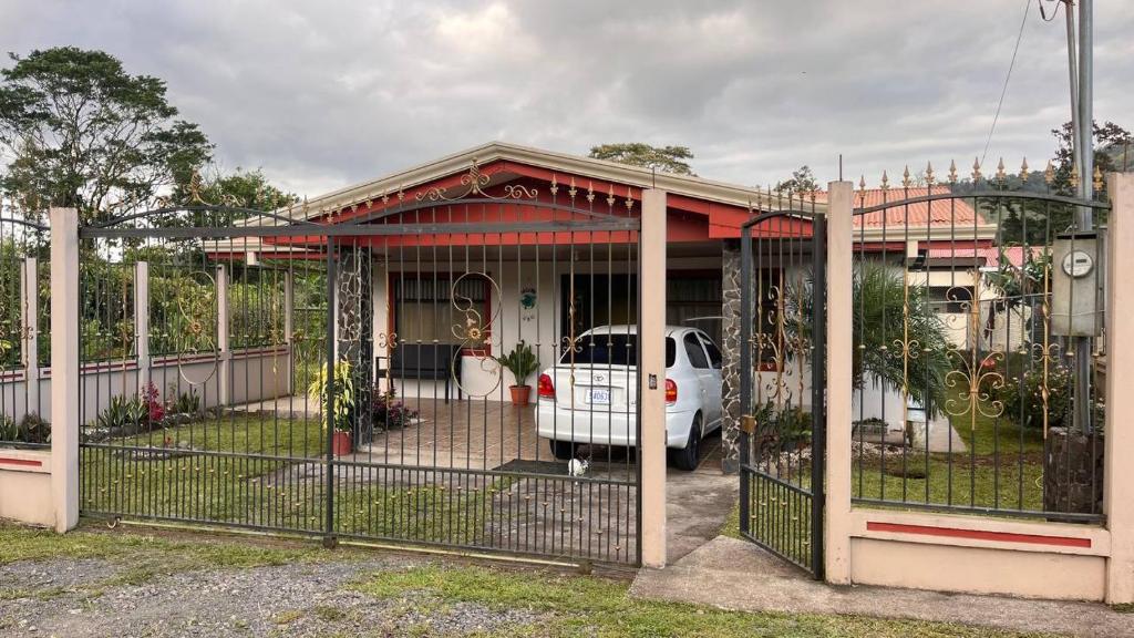 een huis met een hek met een auto erin bij Casa morfo in Bijagua