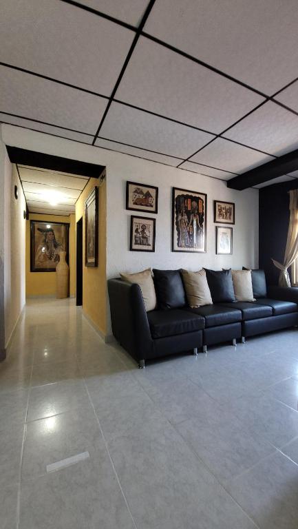 a living room with a black couch in a room at Hotel Mansur in La Tebaida