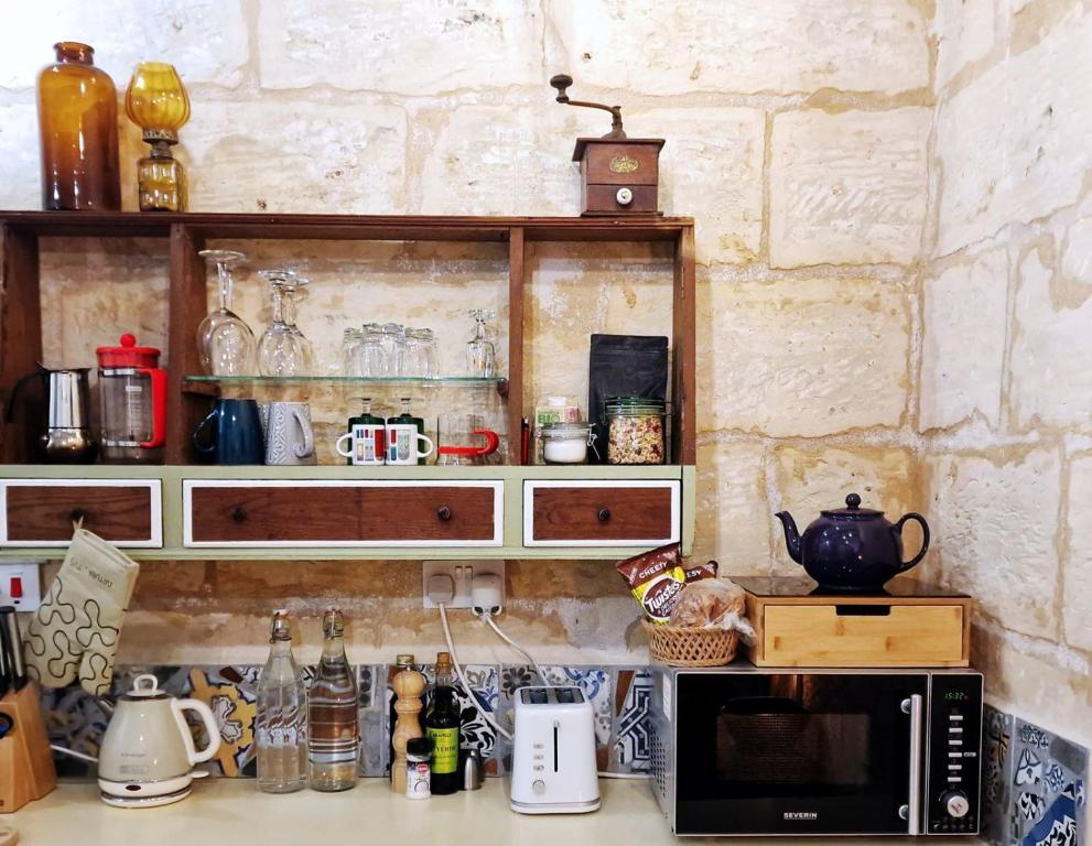 a kitchen with a counter top with a microwave at Myrtle Suite - Valletta ground floor apartment in Valletta