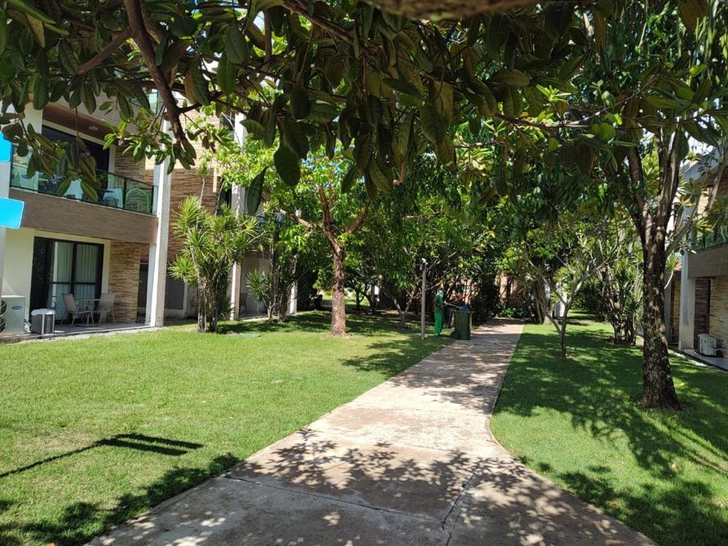 una pasarela frente a un edificio con árboles en Flat no loa Resort & Residence, en Barra de São Miguel