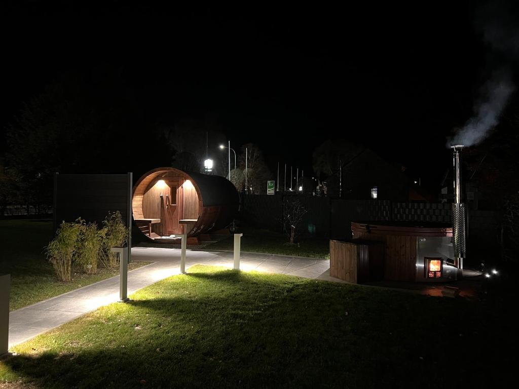 uma pequena cabana de madeira na relva à noite em Traumfabrik Eifel mit Sauna & Whirlpool em Monschau
