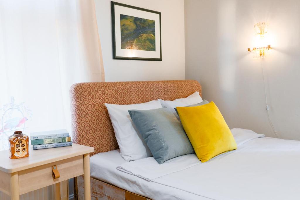a bedroom with two beds and a table with a night stand at Boutique Hotel Marta 8 in Tallinn