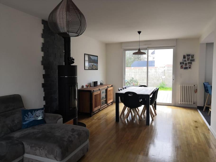 uma sala de estar com um sofá e uma mesa em Maison familiale proche plage em Lorient